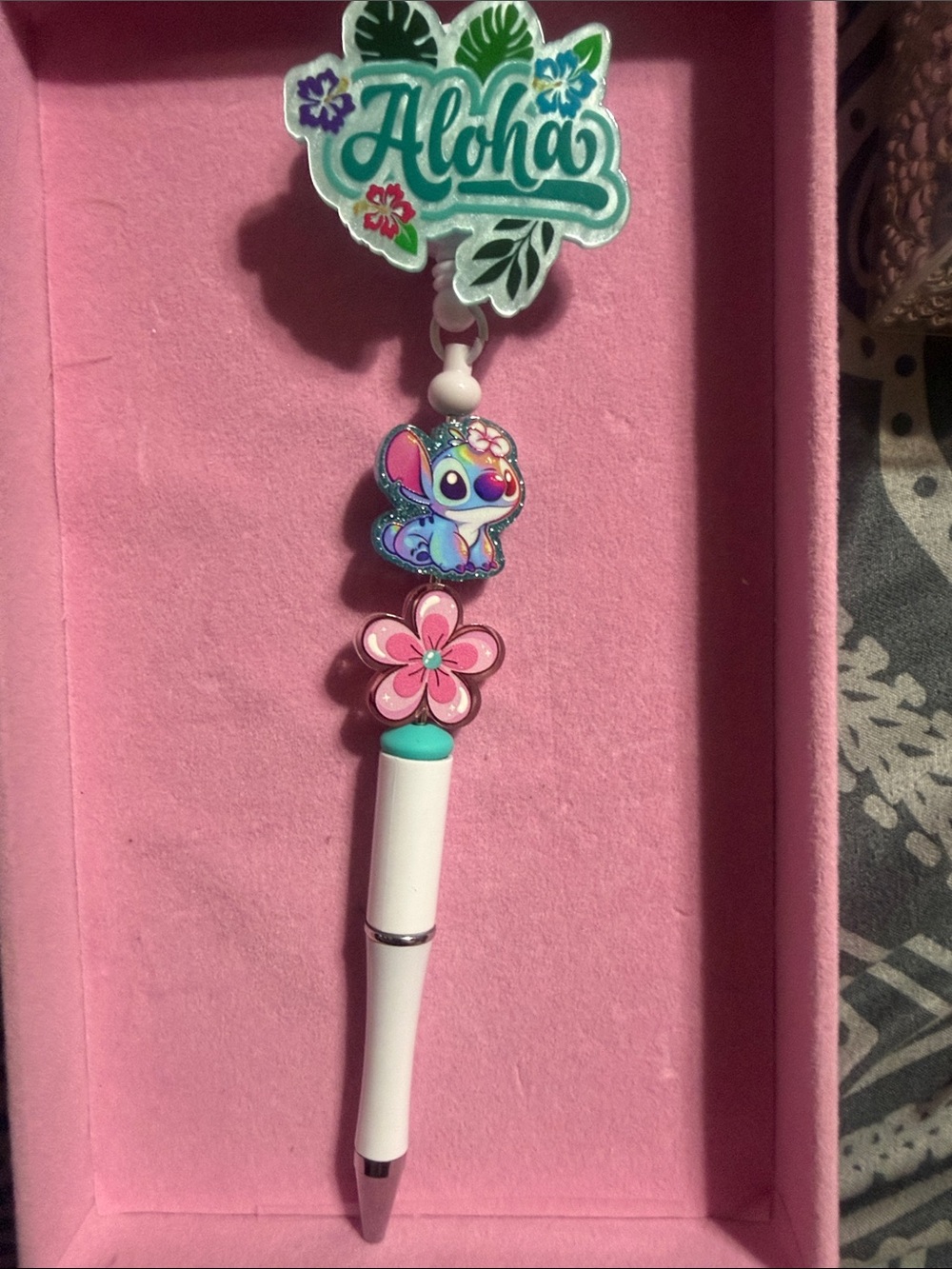 White Aloha beaded badge reel with retractable pen.